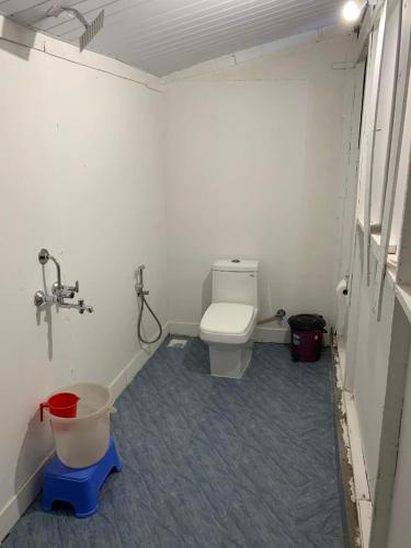 a bathroom with a toilet and a bucket in it at Casa Beach hut Resort in Palolem