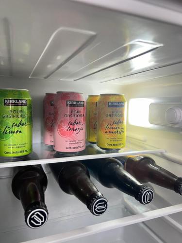 a refrigerator filled with wine bottles and cans at Estudio acogedor en zona costera in Ensenada