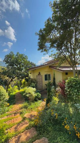 a yellow house with a tree and some bushes at Flora Prairie at Mae Rim, Chiang Mai in Ban Tai