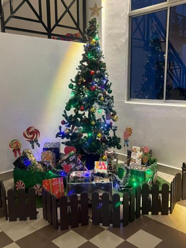 a christmas tree in a room with presents under it at Hotel Seri Malaysia Pulau Pinang in Bayan Lepas
