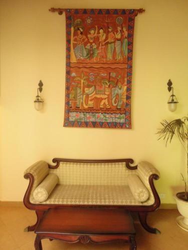 a bench in a room with a painting on the wall at Dedduwa Boat House in Bentota