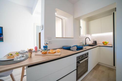 a kitchen with white cabinets and a wooden counter top at Villa Assunta With Pool Near The Sea - Happy Rentals in Melendugno