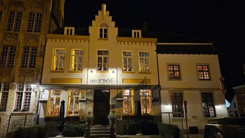 a large building with lit up windows at night at WanT Logies: Ruime loft in Damme