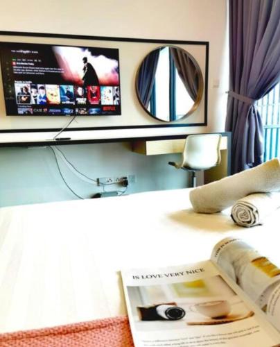 a desk with a television and a magazine on it at Almas Couple Healing Retreat Netflix By STAY in Iskandar Puteri