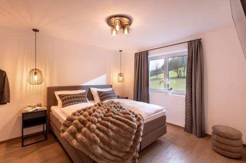 a bedroom with a large bed with a large window at Appartement's Maroslhof in Söll
