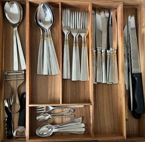 a wooden cabinet with utensils in it at Bijou N 2 Lungern in Lungern