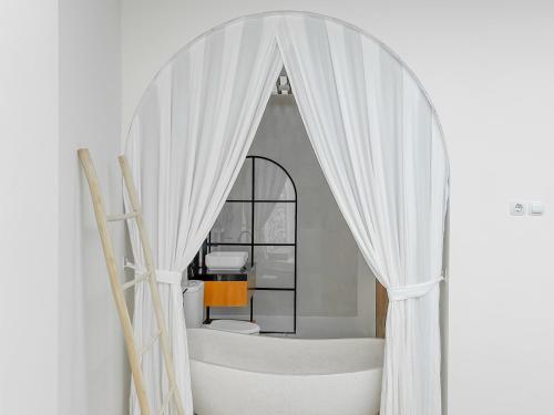 a white bathroom with a tub and a mirror at Tujuan Jogja Villas Arjuna With Private Pool in Jetis