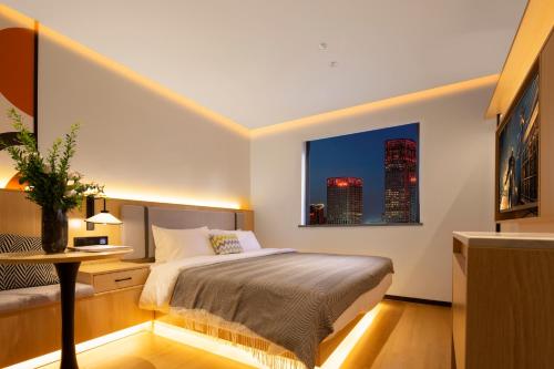 1 dormitorio con 1 cama y una ventana con rascacielos en Mcsrh Hotel-Xi`an Zhonggulou, en Xi'an
