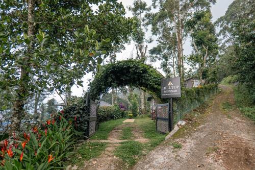 an entrance to a garden with an arch and a sign at Hilltop Munnar by Fracspace in Munnar