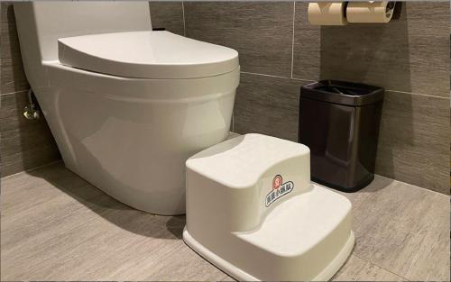 a white toilet in a bathroom with a trash can at Atour Hotel Chongqiang Jiangbei Airport in Chongqing