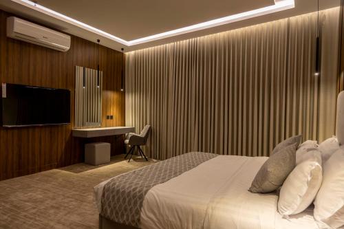 a hotel room with a bed and a desk at نارس البخاري in Buraydah