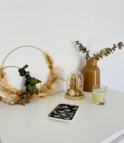 une table avec un verre d'eau et un vase avec des fleurs dans l'établissement Magnifique appartement vue mer, à Vence