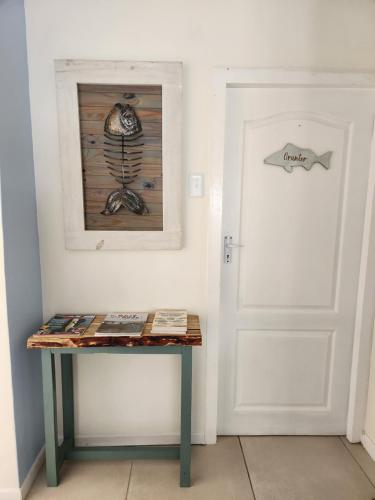 a room with a door and a table with a fish picture at Fisherman's Post in Gouritzmond
