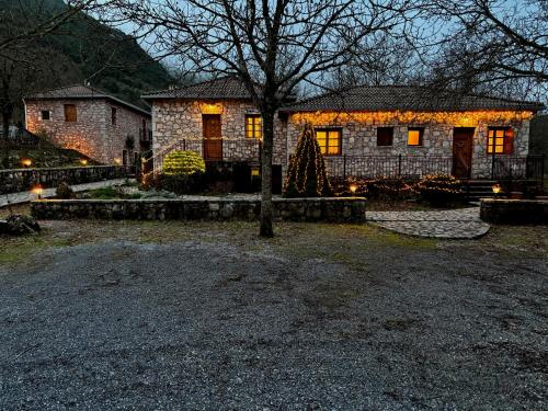 a house with christmas lights in front of it at Andrea Sofi Guesthouse in Dhimitsana