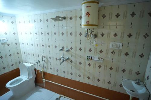 a bathroom with a toilet and a sink at Mango Farm Resort in Udaipur