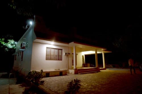 a small white building with a light on it at night at Mango Farm Resort in Udaipur