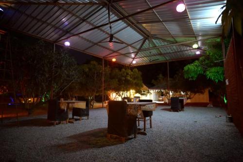 a patio with tables and chairs and lights at Mango Farm Resort in Udaipur