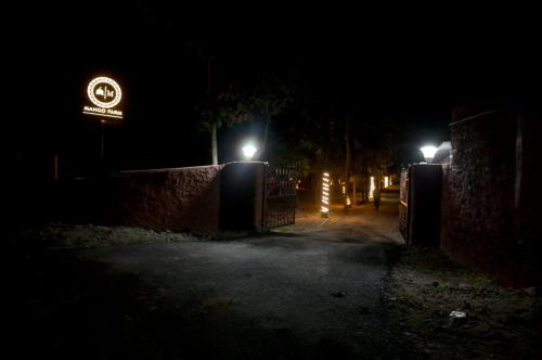 a dark street at night with a sign and lights at Mango Farm Resort in Udaipur
