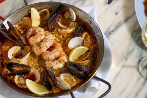a pan filled with shrimp and mussels on a table at The Notary Hotel, Philadelphia, Autograph Collection by Marriott in Philadelphia