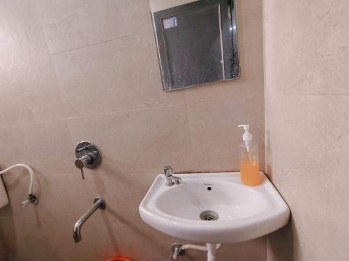 a white sink in a bathroom with a mirror at Malhar Guest House in Pune