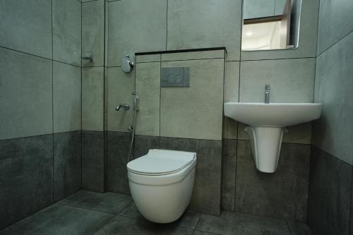 ein Badezimmer mit Toilette und Waschbecken in der Unterkunft Sreeja Myst in Athirappilly