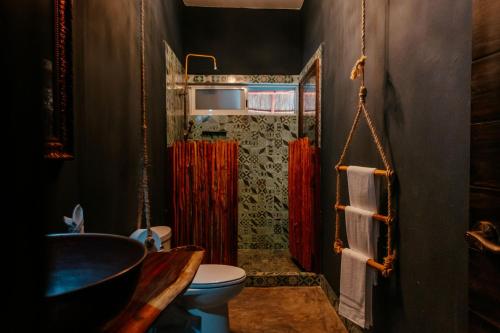 een badkamer met een toilet en een douche met rode gordijnen bij Cielito 1 in Tulum