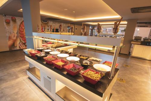 a buffet line with bowls of food on a counter at Orka World Hotel & Aquapark in Oludeniz