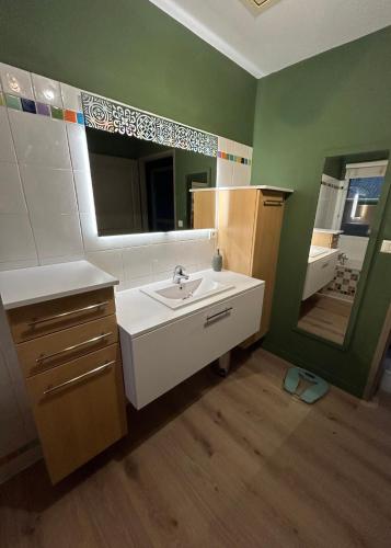 une salle de bain avec un lavabo et un miroir dans l'établissement Villa 8 personnes proche d'Hossegor au bord du Golf de Pinsolle, à Soustons