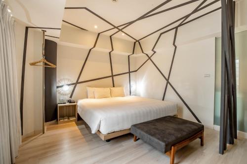 a bedroom with a white bed with a black frame at Hotel Papa Whale-Kaohsiung Formosa Boulevard in Kaohsiung