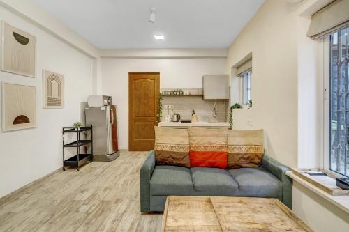 Una sala de estar con un sofá y una cocina. en Cleo 1BHK Khar W by The Bombay Home Company, en Bombay