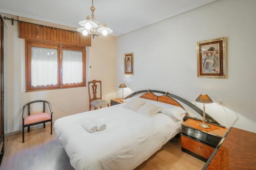 a bedroom with a large white bed and a chair at El Cedro in Abejar