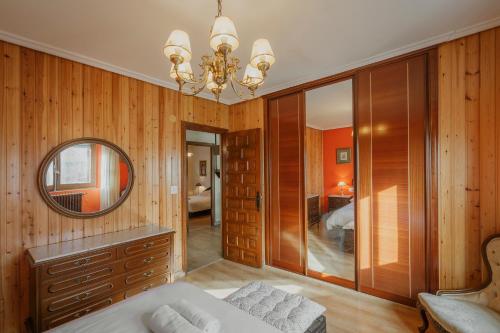 a bedroom with wooden walls and a mirror and a bed at El Cedro in Abejar