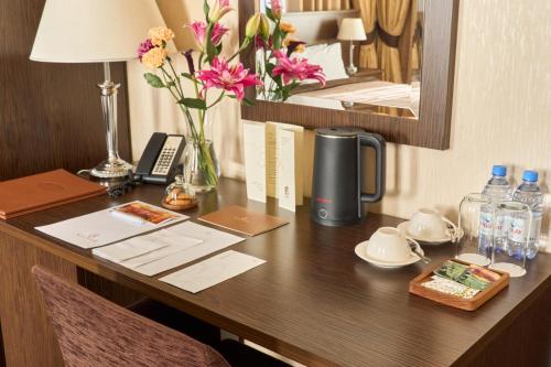 a desk in a hotel room with flowers on it at Kainar Hotel in Shymkent