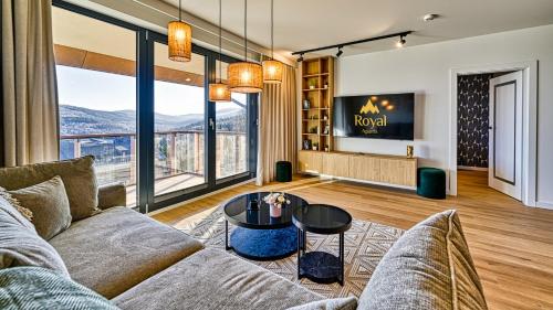 a living room with a couch and a tv at Źródło Izery przy gondoli VIP Sauna, Siłownia, Bawialnia by Royal Aparts in Świeradów-Zdrój