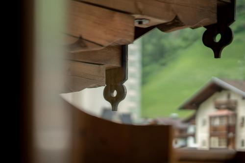 a close up of a wooden table with a house in the background at Ferienpension Senfter in Innervillgraten