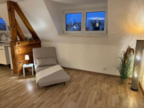 a living room with a chair and two windows at Relaxing in Flachslanden