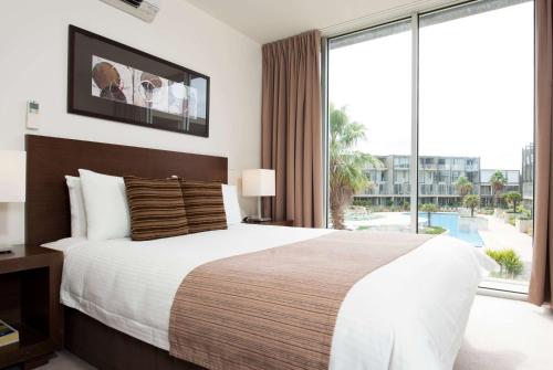 a bedroom with a large bed and a large window at Wyndham Resort Torquay in Torquay