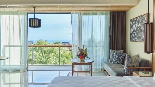 a bedroom with a bed and a large window at AYANA Segara Bali in Jimbaran