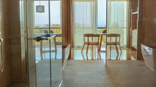 a bird flying over a table and chairs in a room at AYANA Segara Bali in Jimbaran
