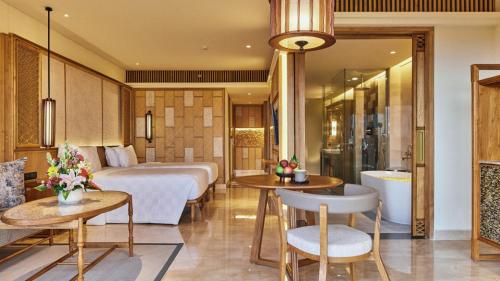 a hotel room with a bed and a bathroom at AYANA Segara Bali in Jimbaran
