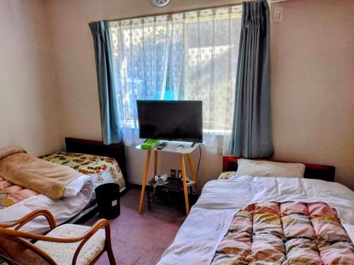 Giường trong phòng chung tại Orange house Izu Simoda