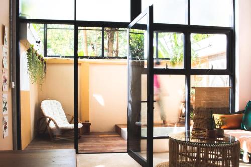 a living room with a sliding glass door with a chair at Takak Villas in Siem Reap