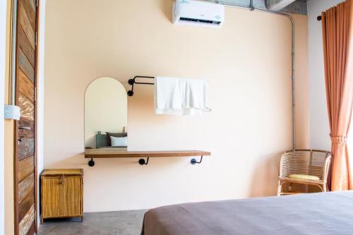 a bedroom with a mirror and a bed and a chair at Takak Villas in Siem Reap