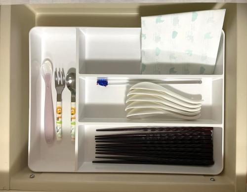 a refrigerator filled with plates and utensils at ユーカラ屋 in Nanae