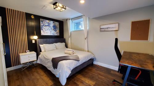 a small bedroom with a bed and a table at Airdrie Modern Walkout Bsmt Suite with Hot Tub in Airdrie