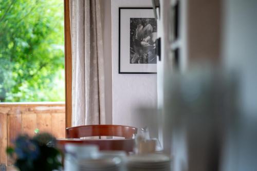 a table with a chair in front of a window at Ferienpension Senfter in Innervillgraten