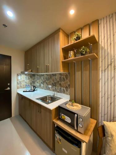 a kitchen with a sink and a microwave at Alpine Villas Greens Staycation at Crosswinds Tagaytay in Tagaytay