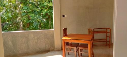 a wooden table and chair next to a window at LaRoy FutureStay - Smart Hotel Mirissa in Mirissa