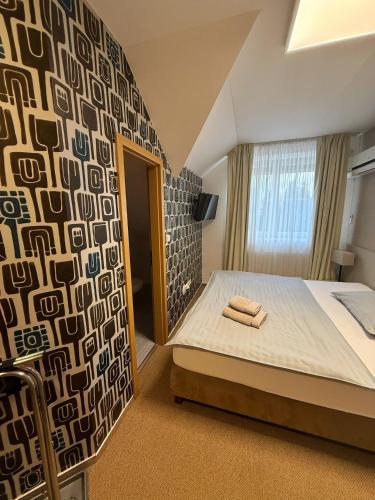 a bedroom with a bed with two towels on it at Penzion Solid Spa in Mladá Boleslav