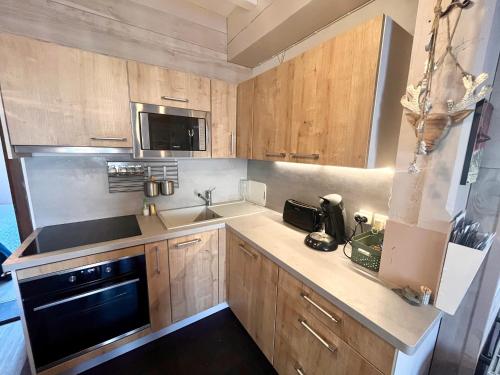 une cuisine avec des armoires en bois et un appareil noir dans l'établissement 